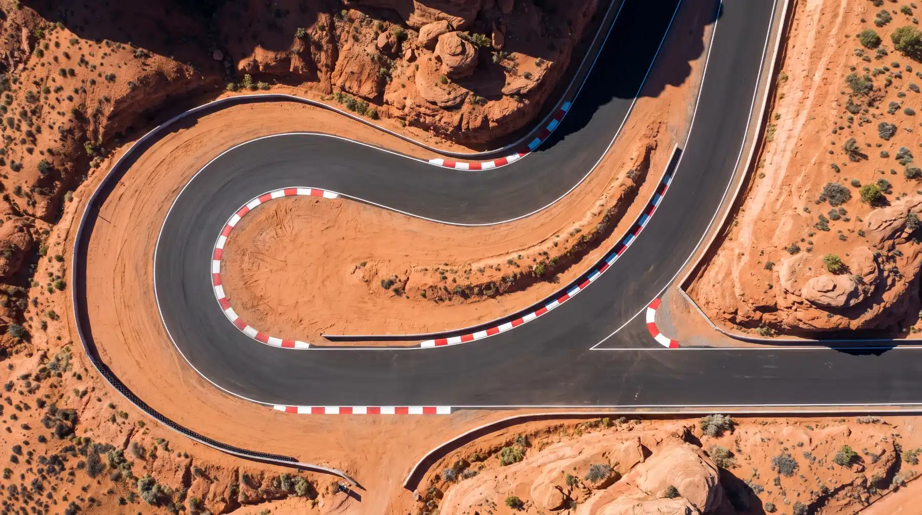 Aerial view of a race track hairpin through Southern Utah red rock